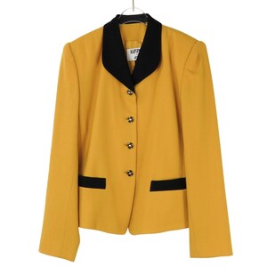 May include: A mustard yellow blazer featuring a contrasting black lapel collar and two black horizontal pocket flaps. The garment includes four gold-toned buttons down the front closure and a white interior label with the text KASPER.