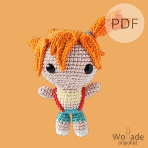 May include: Crocheted amigurumi doll with orange hair, pink skin, and blue overalls. The doll is wearing a red and white striped shirt. The doll is holding its arms out to the sides. The image has the word "PDF" in a white circle.
