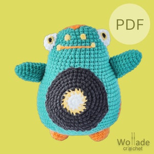 Op de afbeelding: Haak amigurumi patroon PDF voor een tealblauwe en zwarte creatie met oranje accenten. De creatie heeft een grote zwarte cirkel op zijn buik met een wit en geel centrum.