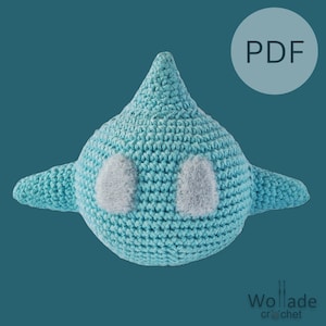 Op de afbeelding: Een lichtblauw gehaakt vliegtuig speelgoed met witte vilt ogen. Het speelgoed is ontworpen om een zacht en knuffelig speelgoed voor kinderen te zijn.