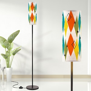 May include: A black floor lamp with a white and orange geometric patterned lampshade. The lampshade has a diamond pattern with green, yellow, and orange accents.