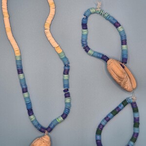 May include: A white ceramic mug with a black handle and the text "But First, Coffee" in a black, handwritten-style font. The mug is on a white surface.