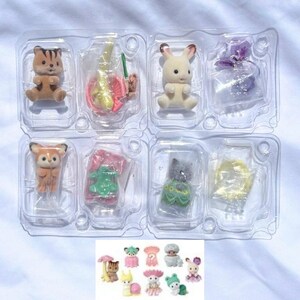 May include: Four small flocked animal figurines in clear plastic packaging. The set includes a brown striped cat, a cream rabbit, a fox, and a gray kitten, each with a small accessory. A small image at the bottom shows all available figures.