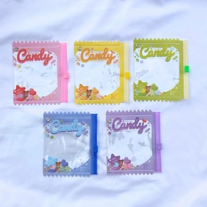 May include: Five colorful candy bags with the word "Candy" in a script font. The bags are pink, yellow, green, blue, and purple. Each bag has a clear window and a decorative border. The bags are decorated with candy and bear graphics.