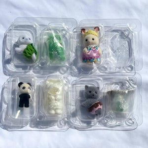 May include: A set of six miniature flocked animal figurines in individual clear plastic blister packaging. The collection includes a white owl, a green accessory, a rabbit in a pink dress, a panda, a white ghost figure, and a gray cat.