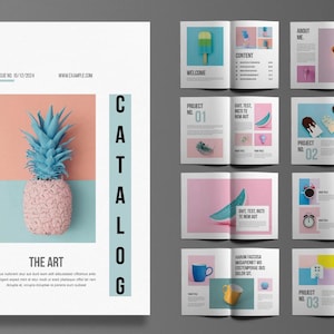 Könnte beinhalten: Ein Produktkatalog-Cover mit einem rosa-blauen Farbschema. Das Cover zeigt eine Ananas mit blauer Spitze und rosa Körper. Der Text "PRODUCT CATALOG" ist vertikal in Schwarz auf der linken Seite des Covers geschrieben. Der Text "THE ART" ist in Schwarz am unteren Rand des Covers geschrieben.