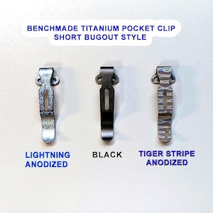 May include: Three Benchmade titanium pocket clips in a row. The first is lightning anodized, the second is black, and the third is tiger stripe anodized. The text "Benchmade Titanium Pocket Clip Short Bugout Style" is at the top, and the color names are below each clip.