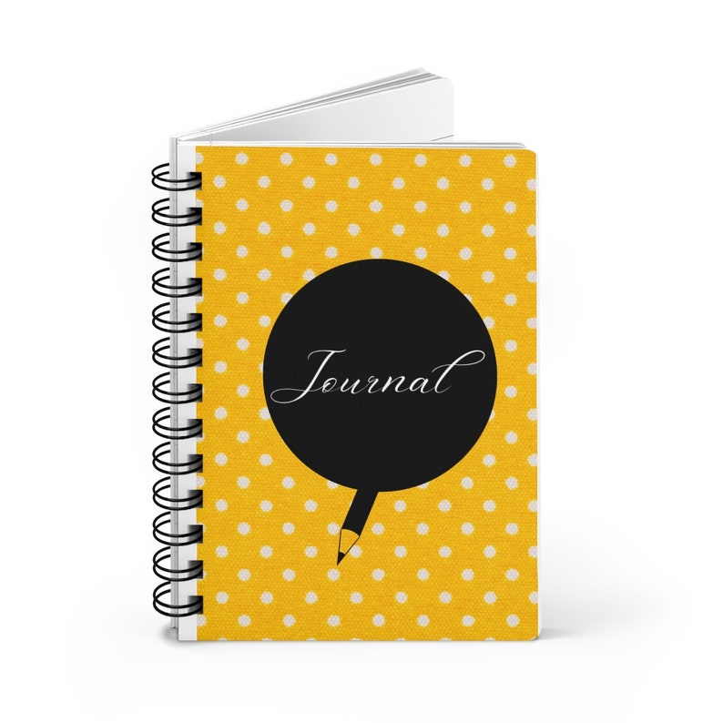 May include: A yellow journal with white polka dots and a black circle with the word "Journal" written in white cursive. A black pencil is drawn coming out of the circle.