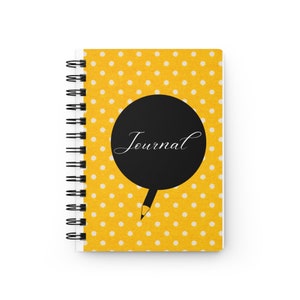May include: Yellow journal with white polka dots and a black circle with the word "Journal" written in white. A black pencil is drawn coming out of the circle.