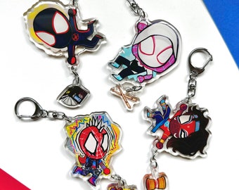May include: Four colorful cartoon character keychains featuring Spider-Man characters. The keychains are made of clear acrylic and feature a silver metal ring. The characters include Spider-Man, Miles Morales, Spider-Gwen, and a black and red Spider-Man character.