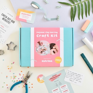 May include: A craft kit for making polymer clay earrings, presented in a light blue box with a pink label. The label displays the text "Polymer Clay Earring Craft Kit" and images of earrings. Includes tools, stationery, and a note. "Handmade in Britain" is also printed.