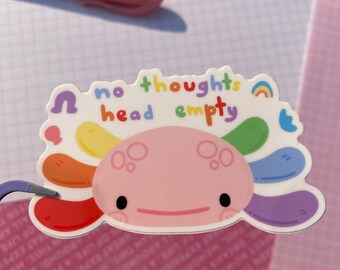 May include: A sticker featuring a pink axolotl with a rainbow-colored tail. The axolotl is smiling and has a rainbow above it. The text "no thoughts head empty" is written in a rainbow font above the axolotl.