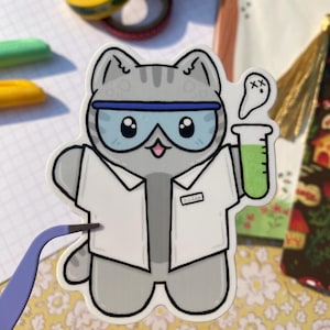May include: A gray cat wearing a white lab coat and blue goggles holds a test tube with green liquid. The cat has a cute expression and a name tag that says "Missa".