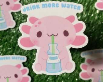 May include: A pink axolotl cartoon character with big eyes and a small mouth is drinking water from a blue bottle with a green straw. The axolotl is sitting on a white background with the text "Drink More Water" in blue letters.