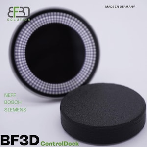 Könnte beinhalten: Ein schwarzer ControlDock für Geräte von Neff, Bosch und Siemens. Der Dock ist aus schwarzem Kunststoff und hat eine strukturierte Oberfläche. Der Dock ist mit "BF3D ControlDock" und "Made in Germany" beschriftet.
