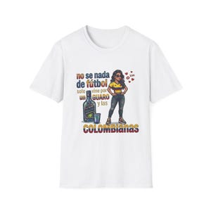 May include: White t-shirt with a graphic of a woman in a yellow and blue top, sunglasses, and distressed jeans. The text on the shirt reads "no se nada de fútbol solo vine por un guaro y las Colombianas."