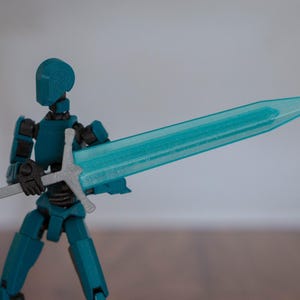 Puede incluir: Una figura de acci&oacute;n azul turquesa sosteniendo una espada azul transl&uacute;cida con una empu&ntilde;adura plateada.