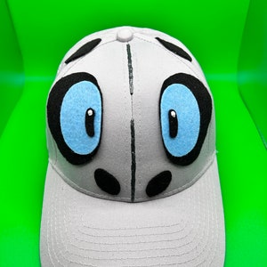 May include: A gray baseball cap with black and white panda bear eyes and a blue felt nose.
