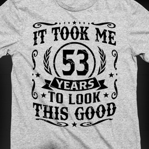 May include: A grey t-shirt with black text that reads "It took me 53 years to look this good".