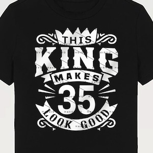 May include: Black t-shirt with a white graphic design that says "This King Makes 35 Look Good" with a crown above the text.