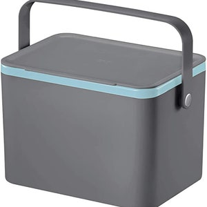 May include: A grey plastic cooler with a blue trim and a handle. The cooler has a lid that can be closed.