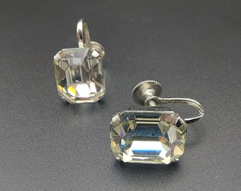 以下が含まれることがあります： 透明な長方形の石が付いた銀色のクリップ式イヤリングのペア