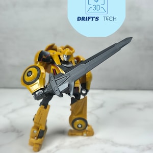 Pode incluir: Uma figura de ação de robô amarelo e preto segurando uma espada preta. A figura faz parte da coleção Studio Series Gamer Edition WFC Sword.