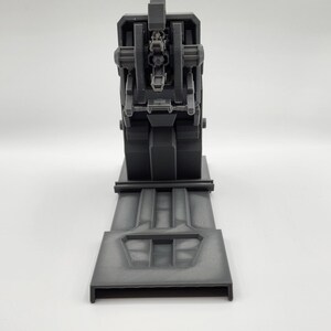 Puede incluir: Un modelo de nave espacial futurista impreso en 3D de color gris con una cabina detallada y una plataforma de aterrizaje.