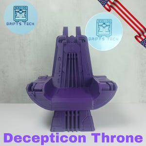 May include: A purple 3D-printed Decepticon Throne. The throne features a detailed design with vertical bars on the back and a stylized emblem. The base is rectangular, and the text "Decepticon Throne" is at the bottom.