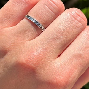 May include: A silver ring with a textured band of small circles.