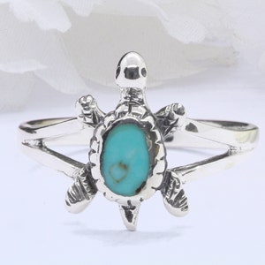 Könnte beinhalten: Silberring aus Sterlingsilber mit einem Türkis-Stein, der in ein Schildkröten-Design eingefasst ist.