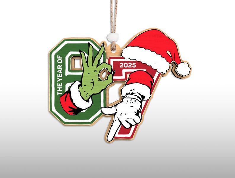 May include: Wooden Christmas ornament with the numbers 9 and 7, and the year 2025. The number 9 features a green hand with a red and white cuff, making an "okay" gesture. The number 7 has a Santa hat and a white hand pointing down.