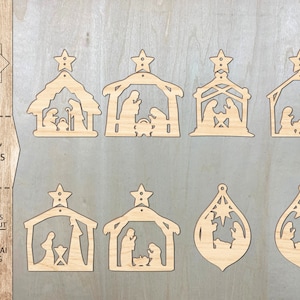 May include: A collection of laser-cut wooden Nativity earrings in various designs. The earrings feature silhouettes of the Nativity scene, including Mary, Joseph, and baby Jesus. The text "NATIVITY EARRINGS" is visible. Digital files for laser cut are also listed.
