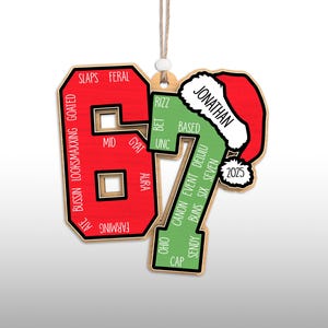 May include: Wooden Christmas ornament in the shape of the number 67, with a Santa hat on the 7. The 6 is red with white text, and the 7 is green with white text. The ornament has the name "Jonathan" and the year "2025".
