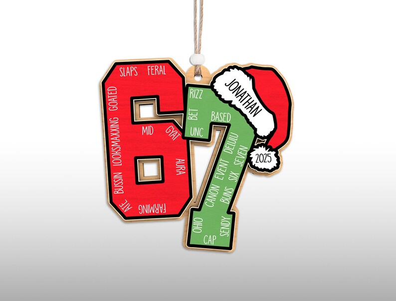 May include: Wooden Christmas ornament in the shape of the number 67, with a Santa hat on the 7. The 6 is red with white text, and the 7 is green with white text. The ornament has the name "Jonathan" and the year "2025".