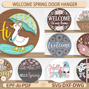 May include: A selection of circular wooden door hangers with spring designs. Some feature floral arrangements, welcome messages, and the text "Hello Spring". One shows a duck with an umbrella.