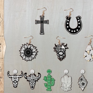 May include: A set of 10 western themed earring designs, including a sunflower, a horseshoe, a cross, a cow, a cactus, a skull, and a cowboy hat. The designs are black and white and are suitable for laser cutting.
