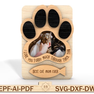 Puede incluir: Marco de fotos de madera con forma de huella de pata de gato con una foto de gato en su interior. El marco tiene el texto "I love you furry much through thick and thin" y "Best cat mom ever" con un dise&ntilde;o de pez.