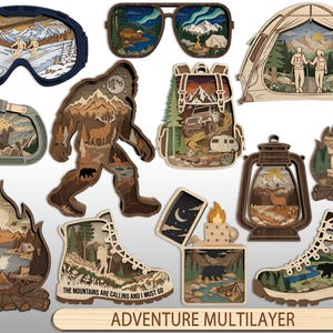 May include: A collection of multilayered wooden laser-cut ornaments featuring outdoor themes including ski goggles, sunglasses, a tent, a carabiner, Bigfoot, a backpack, a lantern, a campfire, a lighter, and hiking boots with the text Adventure Multilayer.