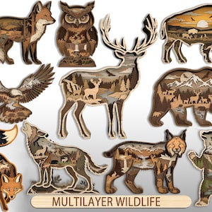 Peut inclure: Une collection de dix silhouettes d'animaux en bois multicouches, dont un renard, un hibou, un cerf, un aigle, un ours, un loup et un lynx. Chaque découpe présente des paysages complexes avec montagnes, forêts et rivières. Le texte MULTILAYER WILDLIFE est visible.