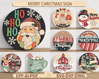 Op de afbeelding: Een verzameling ronde houten kerstborden met diverse ontwerpen. Eén bord toont de kerstman met "HO HO HO", een ander een sneeuwpop, en andere tonen feestelijke thema's zoals rendieren, bomen en een kerk. De borden zijn kleurrijk en decoratief.