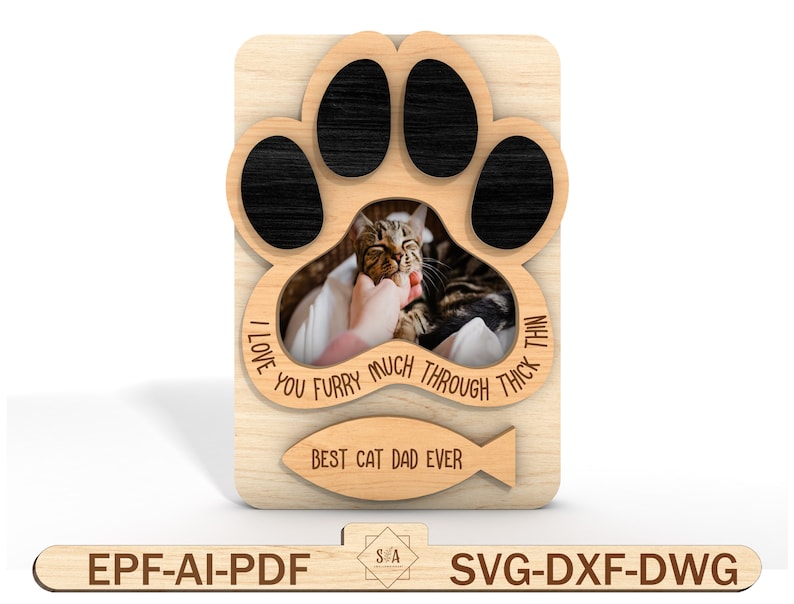 Puede incluir: Un marco de fotos de madera con forma de huella de pata con un recorte para una foto. El marco tiene el texto "I love you furry much through thick and thin" y "Best cat dad ever" con un icono de pez.