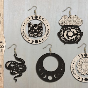 May include: Set of four laser cut wooden earrings with mystical themes. The earrings feature a black cat, a cauldron with a crescent moon, a sun with a face, and a crescent moon with stars.