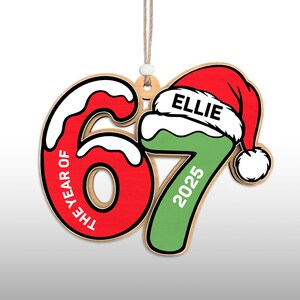 May include: Wooden Christmas ornament in the shape of the number 67, with the text "THE YEAR OF" on the 6 and "2025" on the 7. The 7 is green and topped with a red Santa hat with the name "ELLIE".