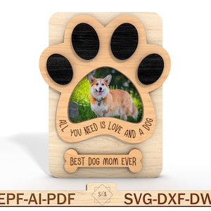 Puede incluir: Un marco de fotos de madera con forma de huella de pata con una foto en blanco y negro de un perro en su interior. El marco tiene el texto "Todo lo que necesitas es amor y un perro" y "Mejor mam&aacute; de perro de la historia" grabado en &eacute;l.