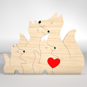 May include: Wooden cutout of a family of foxes, with a red heart in the center. The foxes are all facing forward, with the largest fox in the back and the smallest fox in the front. The foxes are all in a hugging position, with their tails intertwined.