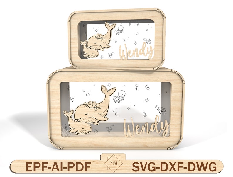 Puede incluir: Dos cajas de madera con un dise&ntilde;o de ballena y ballenato. Las cajas tienen una ventana transparente y el nombre "Wendy" est&aacute; escrito en la parte delantera.