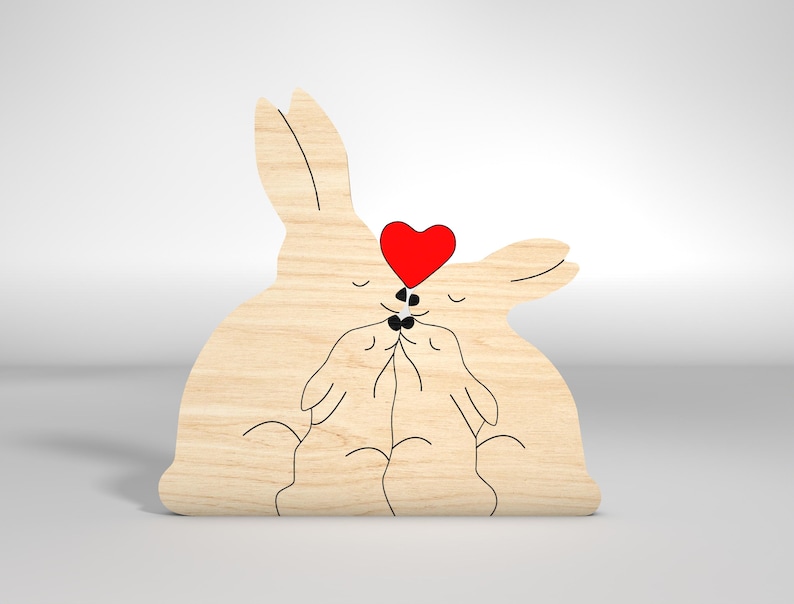 May include: A wooden cutout of two rabbits kissing with a red heart above them.