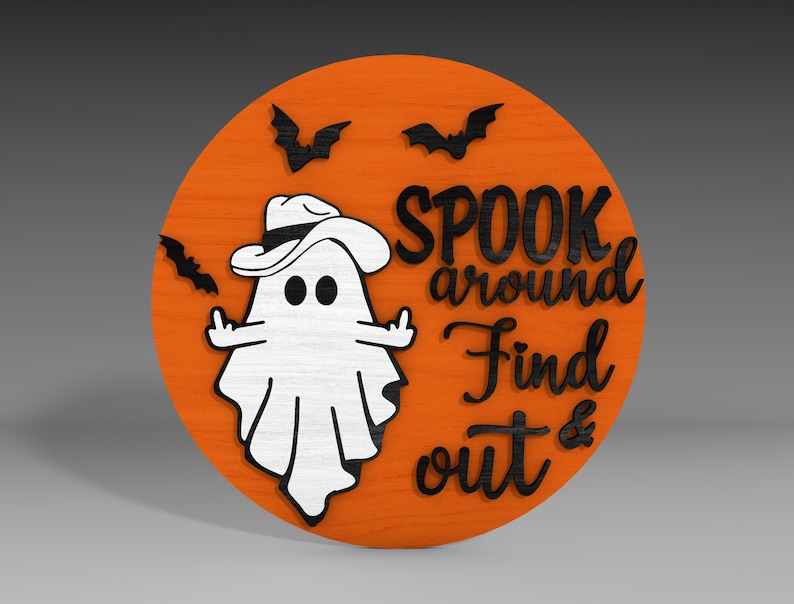 Op de afbeelding: Een rond, oranje houten bord met een witte geest die een zwarte cowboyhoed draagt en de tekst "SPOOK around Find out &" in zwart.