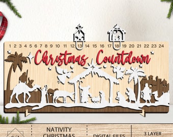 May include: A wooden Christmas countdown calendar with a nativity scene design. The calendar features a white silhouette of the nativity scene with a red "Christmas Countdown" title. The numbers 1 through 24 are printed on the top of the calendar.